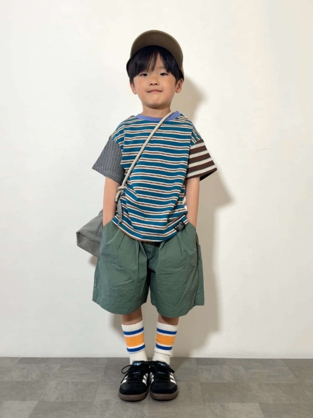 グレー系のショルダーバッグ、ブラック系のスニーカー、その他のTシャツ/カットソーを着用したキッズの春コーディネートの1枚目の写真