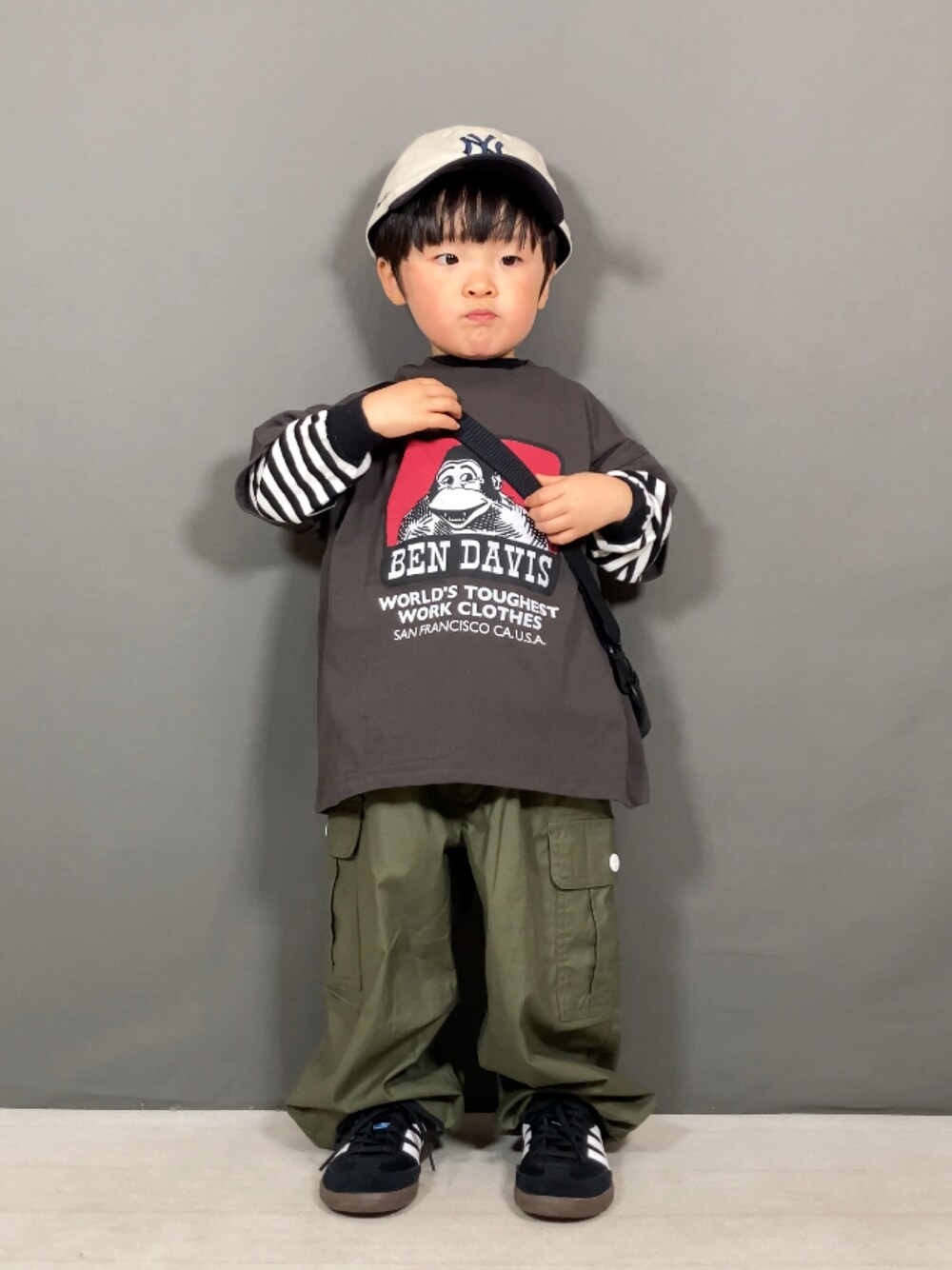 「春のNewスタイル、ボーダー、スニーカー、キャップ、ストリート、アウトドアスタイル、ショルダーバッグ、カーゴパンツ、お出かけコーデ、休日スタイル、カジュアルコーデ、スポーツミックス、春コーデ、レイヤードスタイル」｜「BEN DAVISの【BEN DAVIS】別注プリントT（100～160cm）（Tシャツ/カットソー、グレー系）」を使った、YU⭐︎さん（キッズ・90cm）の春コーディネートの1枚目の写真