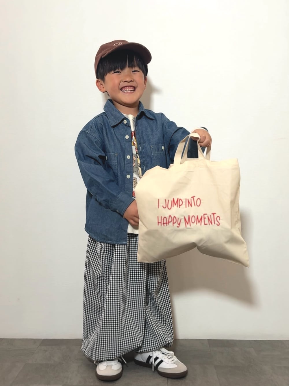 ブラック系のその他パンツ、ベージュ系のトートバッグ、ホワイト系のTシャツ/カットソーを着用したキッズの春コーディネートの1枚目の写真