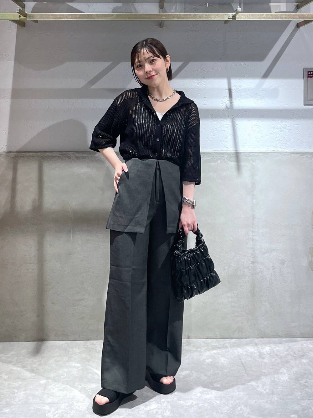 ブラック系のサンダル、ブラック系のショルダーバッグ、ブラック系のニット/セーターを着用したレディースの春コーディネートの1枚目の写真