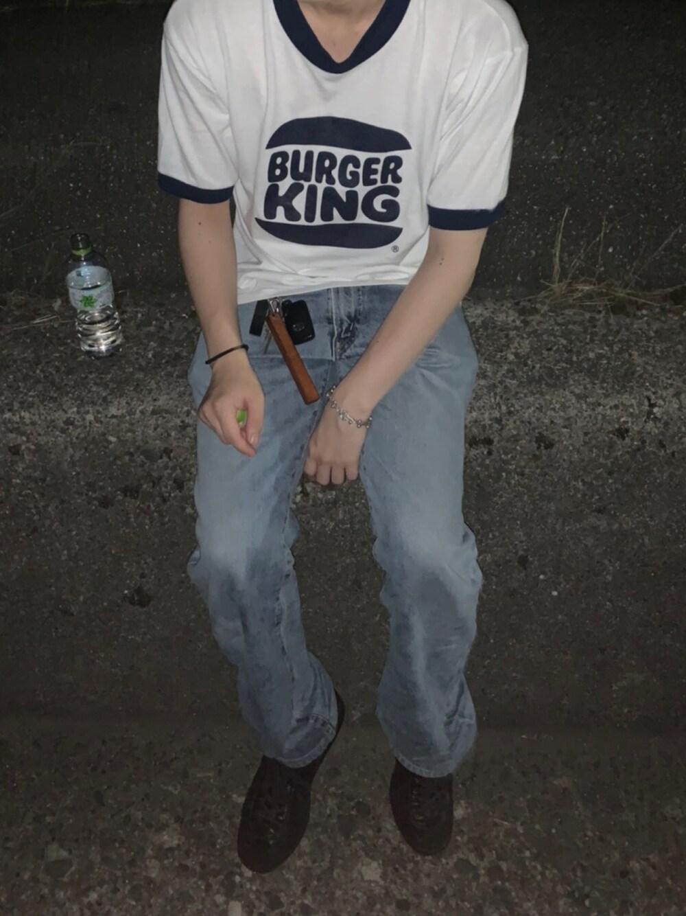 ブラック系のスニーカー、ベージュ系のキーホルダー、シルバー系のブレスレットを着用したメンズの夏コーディネートの1枚目の写真