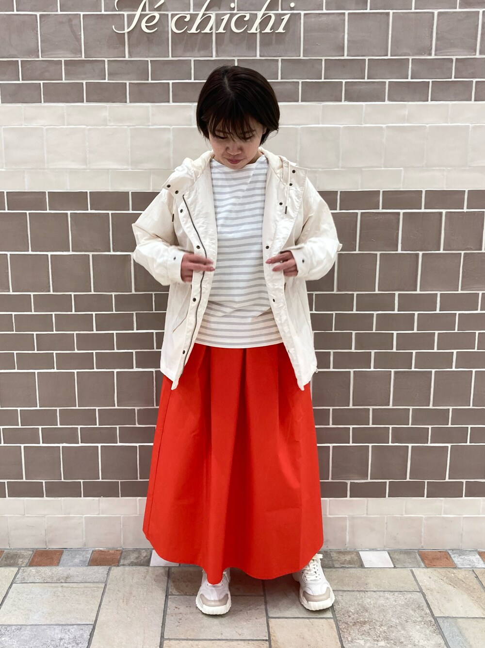 グレー系のTシャツ/カットソー、レッド系のスカート、ホワイト系のノーカラージャケットを着用したレディースの春コーディネートの1枚目の写真