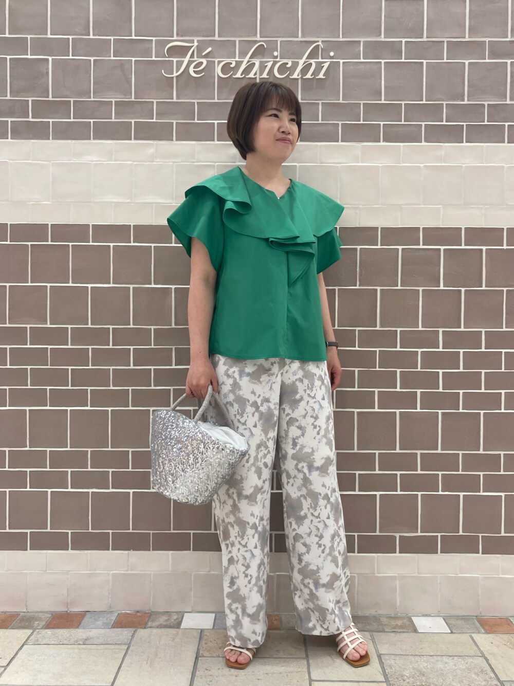 グリーン系のシャツ/ブラウス、シルバー系のハンドバッグ、ベージュ系のその他パンツを着用したレディースの春コーディネートの1枚目の写真