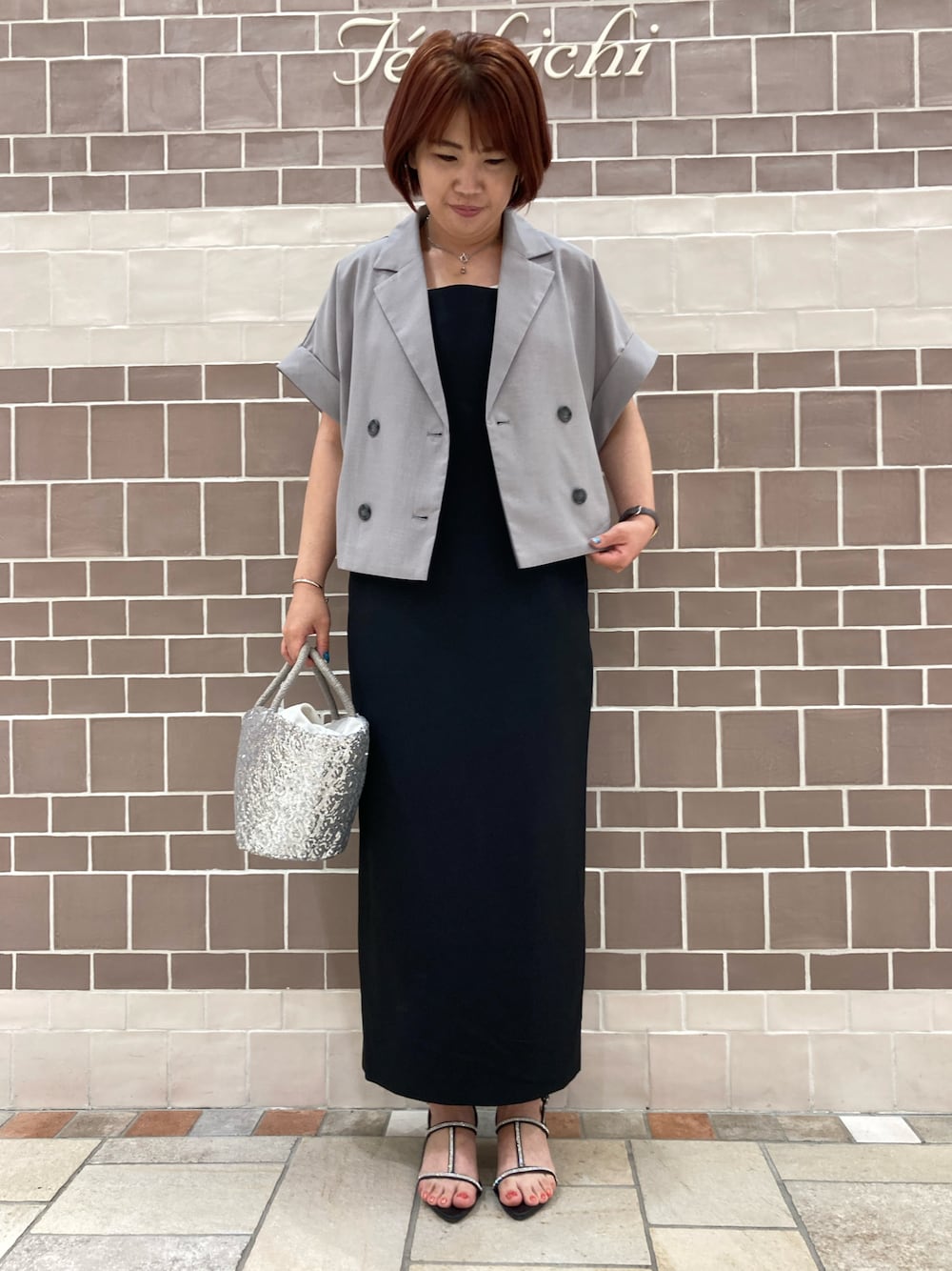 ブラック系のワンピース/ドレス、グレー系のノーカラージャケット、シルバー系のハンドバッグを着用したレディースの夏コーディネートの1枚目の写真