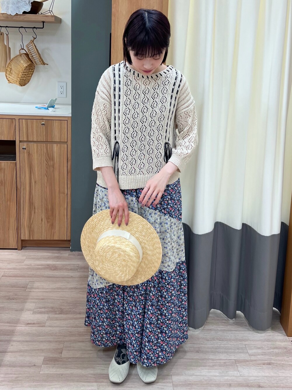 ベージュ系のニット/セーター、ブラック系のスカート、ホワイト系のパンプスを着用したレディースの春コーディネートの1枚目の写真