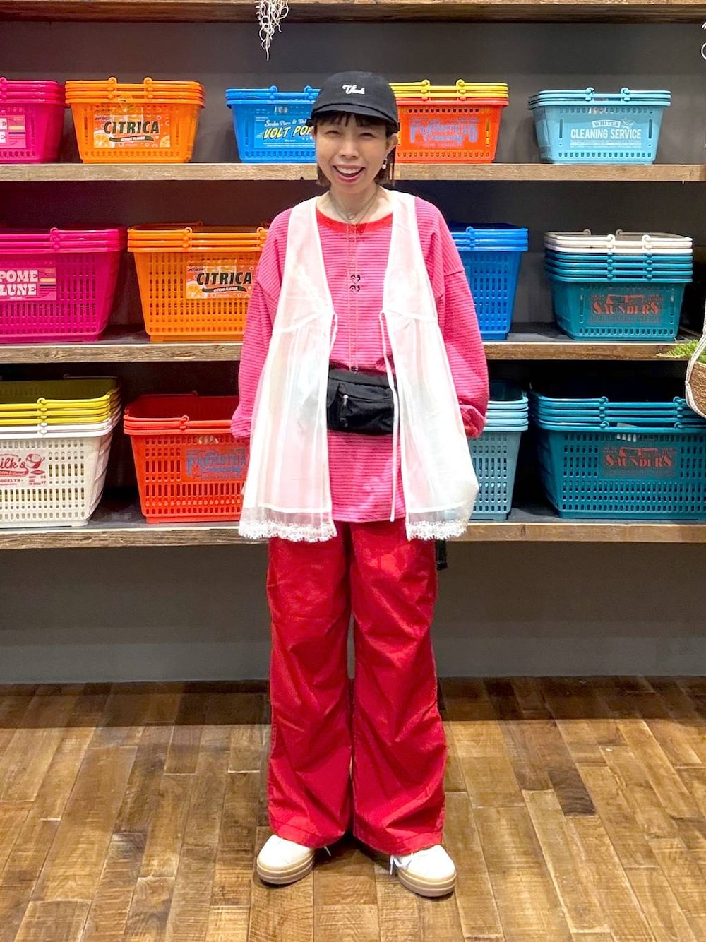 ベージュ系のスニーカー、ホワイト系のベスト、ブラック系のボディバッグ/ウエストポーチを着用したレディースの春コーディネートの1枚目の写真