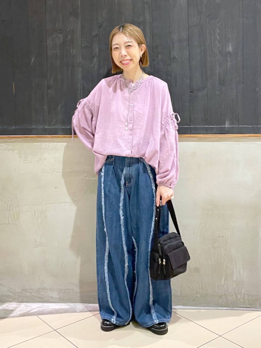 ブラック系のその他シューズ、ブルー系のデニムパンツ、ブラック系のショルダーバッグを着用したレディースの夏コーディネートの1枚目の写真