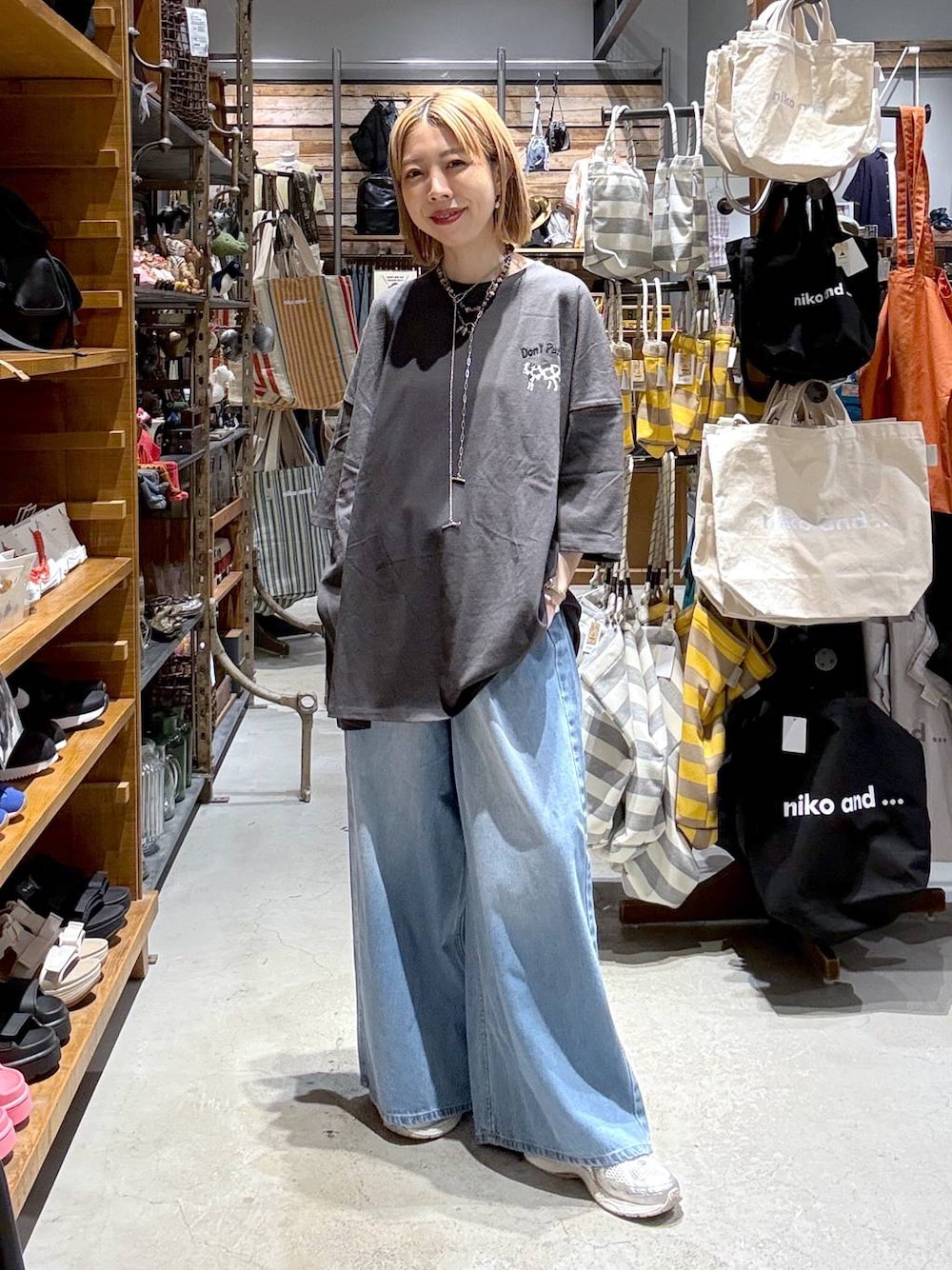 グレー系のTシャツ/カットソー、ブルー系のデニムパンツを着用したレディースの夏コーディネートの1枚目の写真