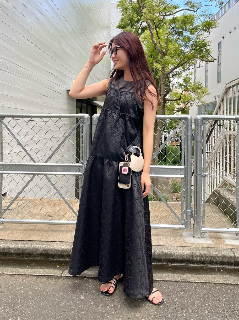 ブラック系のワンピース、ブラック系のスマホグッズ、ブラック系のパスケースを着用したレディースの夏コーディネートの1枚目の写真
