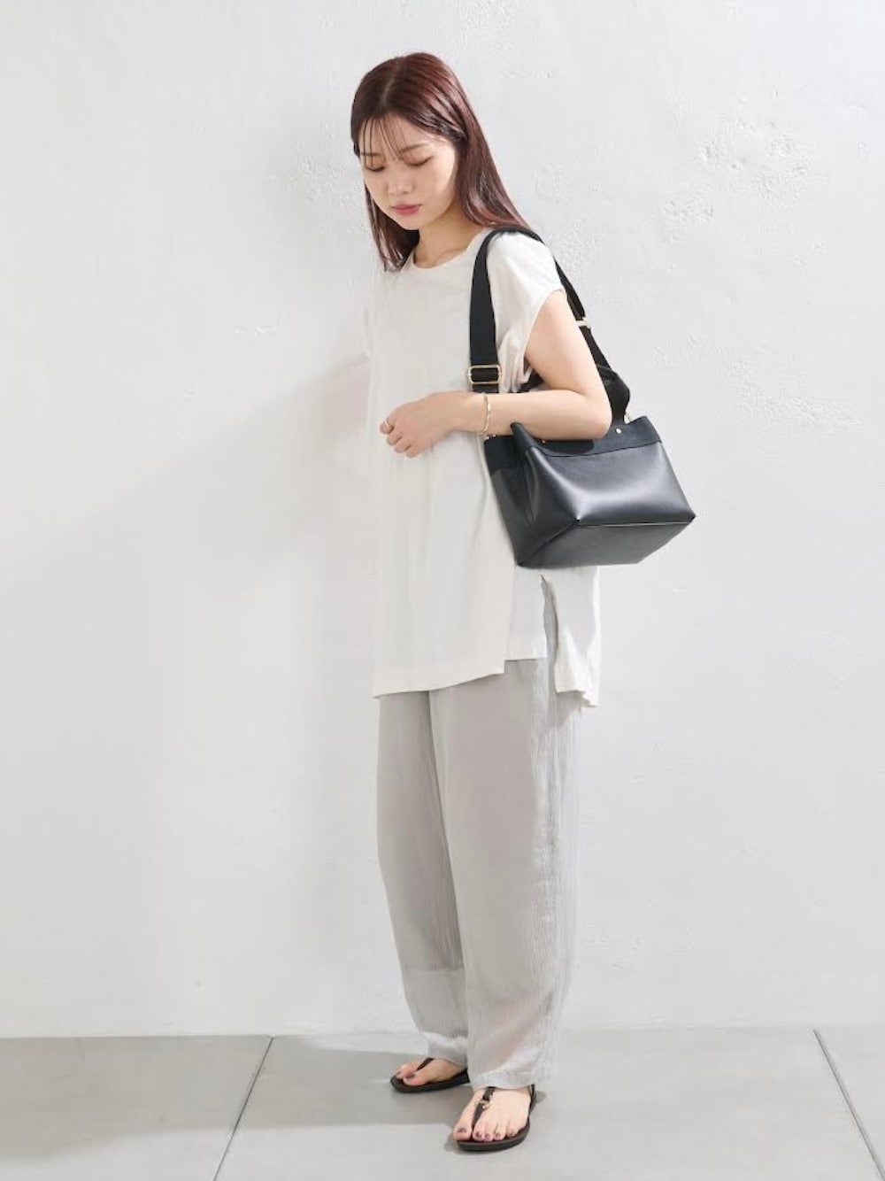 ホワイト系のTシャツ/カットソー、ブルー系のその他パンツ、ブラック系のサンダルを着用したレディースの春コーディネートの1枚目の写真