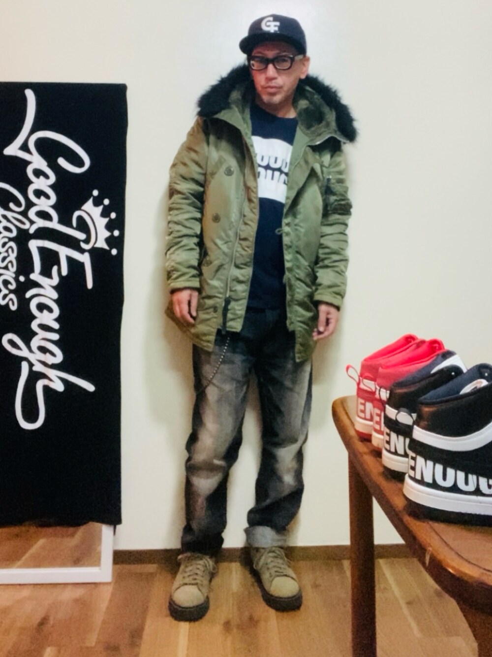 ブルー系のTシャツ/カットソー、グリーン系のミリタリージャケット、ブラック系のデニムパンツを着用したメンズの秋コーディネートの1枚目の写真