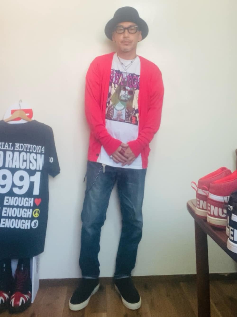 ピンク系のカーディガン/ボレロ、ホワイト系のTシャツ/カットソー、ブルー系のデニムパンツを着用したメンズの秋コーディネートの1枚目の写真