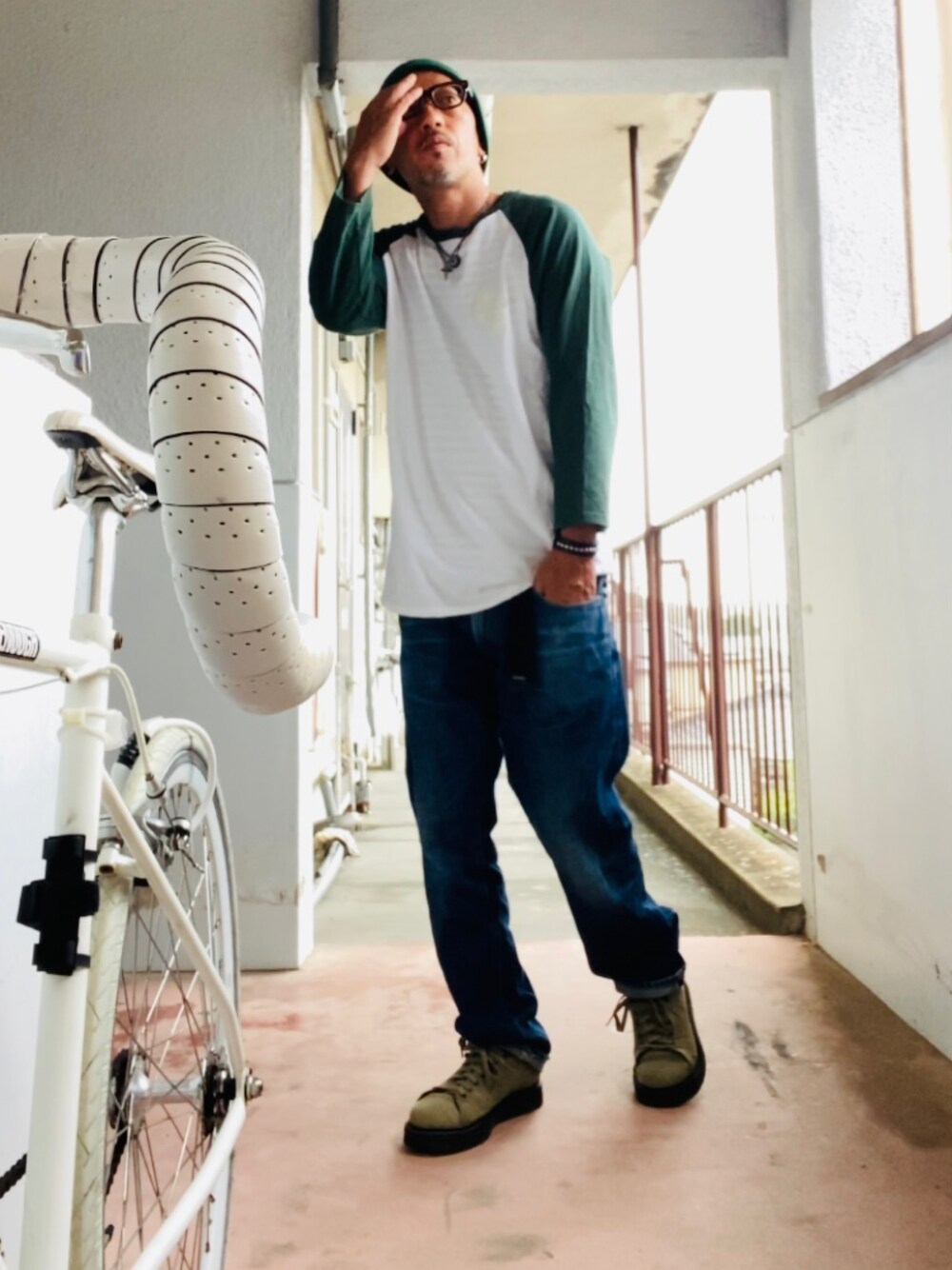 グリーン系のTシャツ/カットソー、ブルー系のデニムパンツ、グリーン系のスニーカーを着用したメンズの秋コーディネートの1枚目の写真