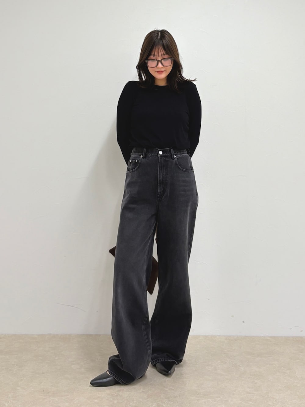 ブルー系のデニムパンツ、ブラック系のTシャツ/カットソー、ブラウン系のショルダーバッグを着用したレディースの夏コーディネートの1枚目の写真