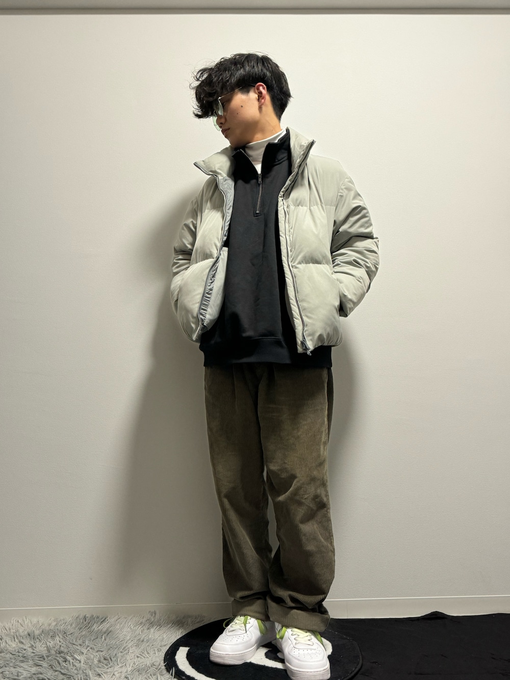 グレー系のダウンジャケット/コート、グリーン系のその他パンツ、ホワイト系のスニーカーを着用したメンズの春コーディネートの1枚目の写真