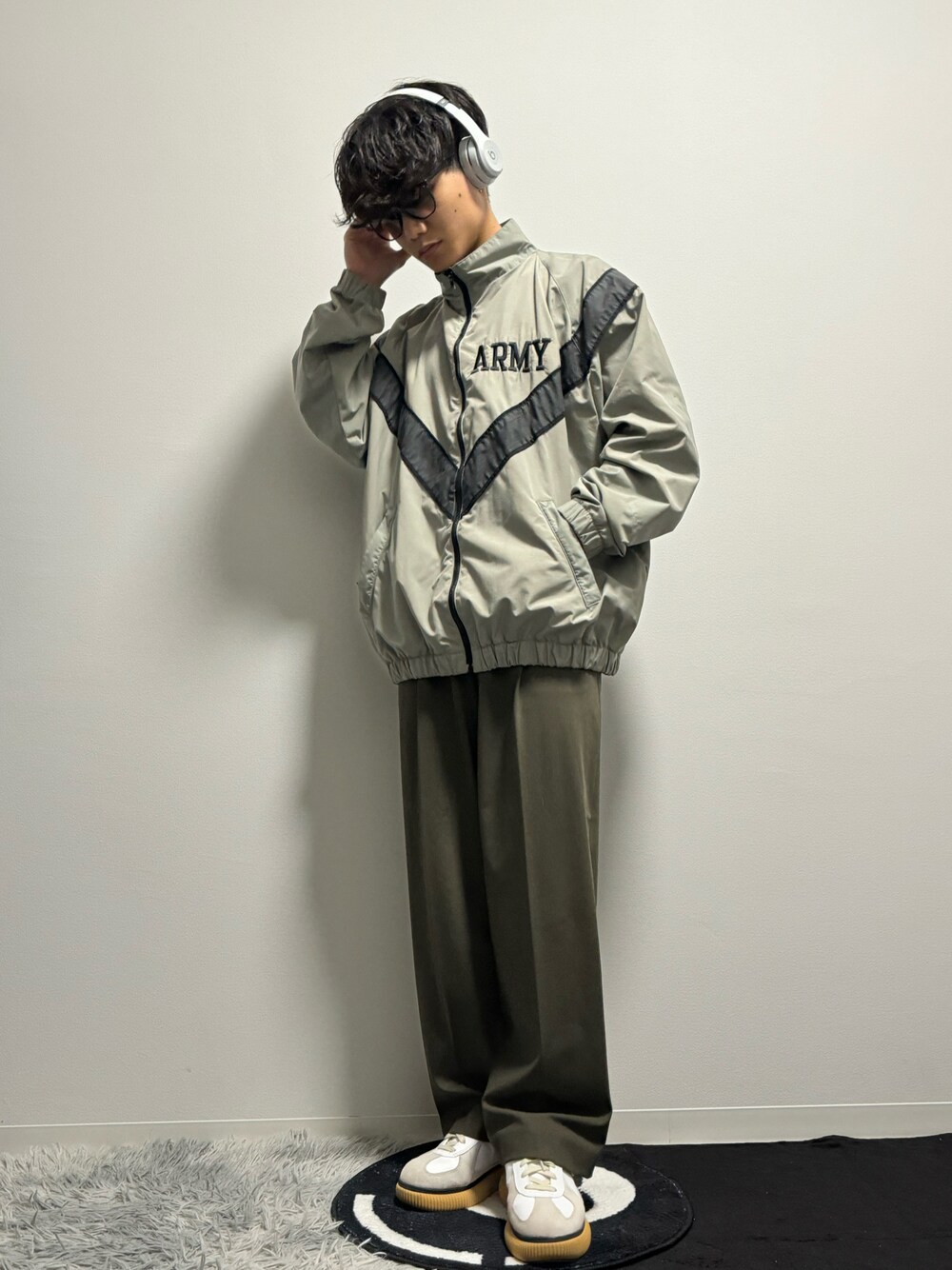 グリーン系のスラックス、グリーン系のスニーカー、グリーン系のミリタリージャケットを着用したメンズの春コーディネートの1枚目の写真