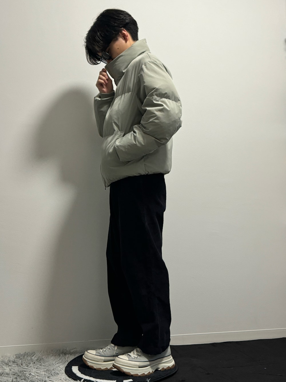 グレー系のダウンジャケット/コート、ブラック系のその他パンツ、グレー系のスニーカーを着用したメンズの春コーディネートの1枚目の写真