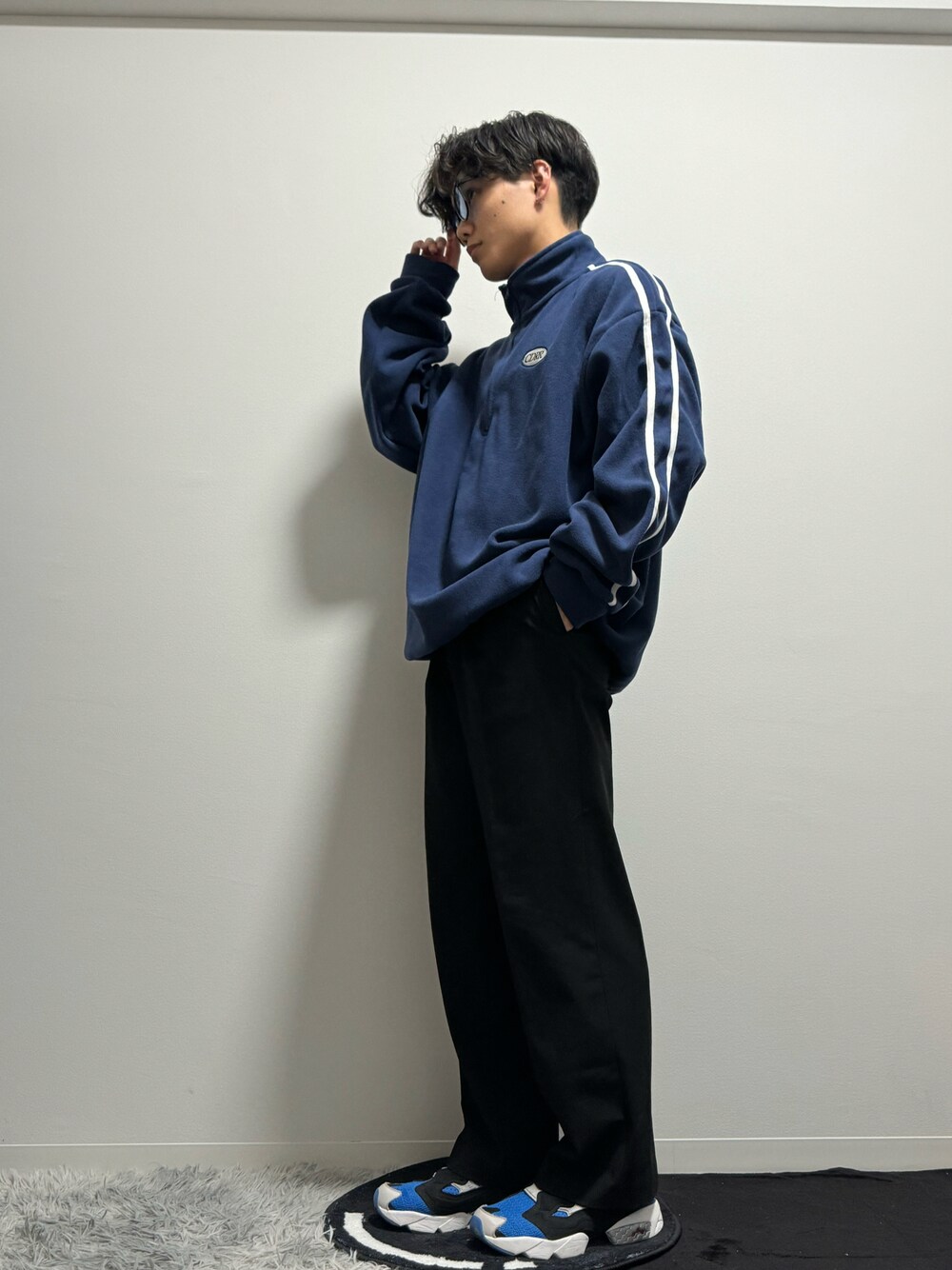 ブルー系のスニーカー、ブラック系のスラックス、ブルー系のスウェットを着用したメンズの春コーディネートの1枚目の写真