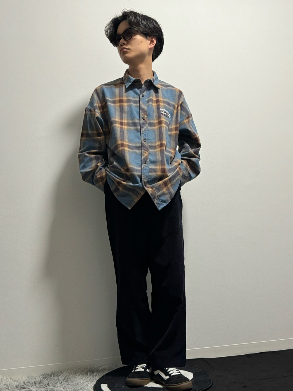 ブラック系のその他パンツ、ブラック系のスニーカーを着用したメンズの春コーディネートの1枚目の写真