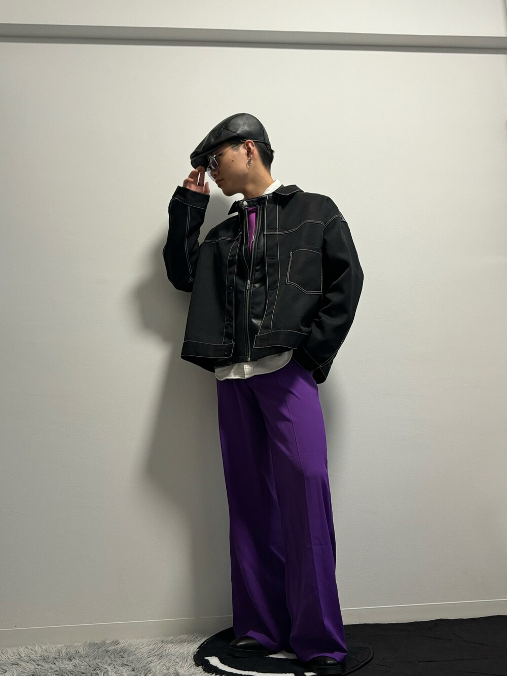 パープル系のスラックス、ブラック系のブーツ、ブラック系のブルゾンを着用したメンズの冬コーディネートの1枚目の写真