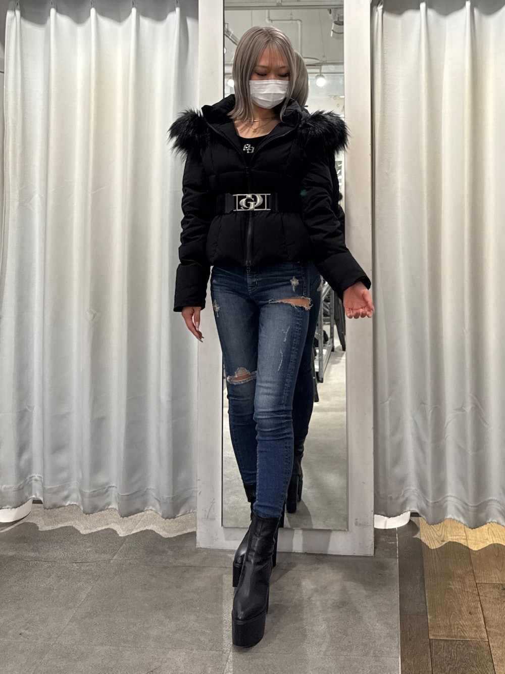 ブラック系のダウンジャケット/コート、ブルー系のデニムパンツ、ブラック系のブーツを着用したレディースの秋コーディネートの1枚目の写真