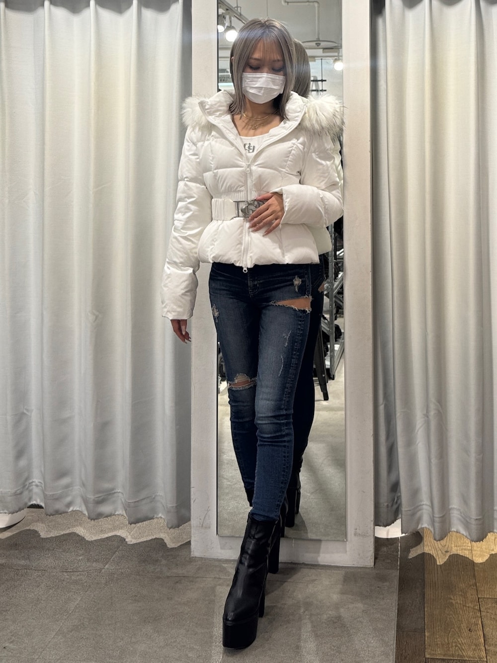 ホワイト系のダウンジャケット/コート、ブルー系のデニムパンツ、ブラック系のブーツを着用したレディースの秋コーディネートの1枚目の写真