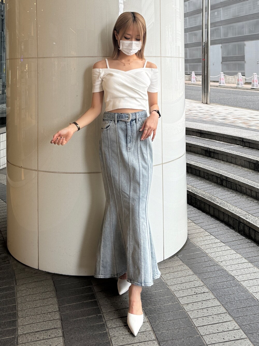 ホワイト系のTシャツ/カットソー、ブルー系のデニムスカート、ホワイト系のパンプスを着用したレディースの夏コーディネートの1枚目の写真