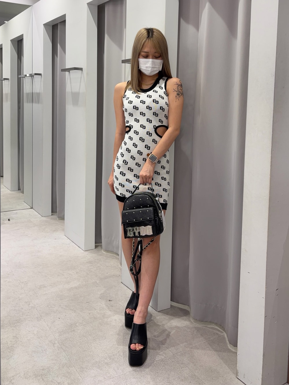 ホワイト系のワンピース、ブラック系のバックパック/リュック、ブラック系のサンダルを着用したレディースの夏コーディネートの1枚目の写真