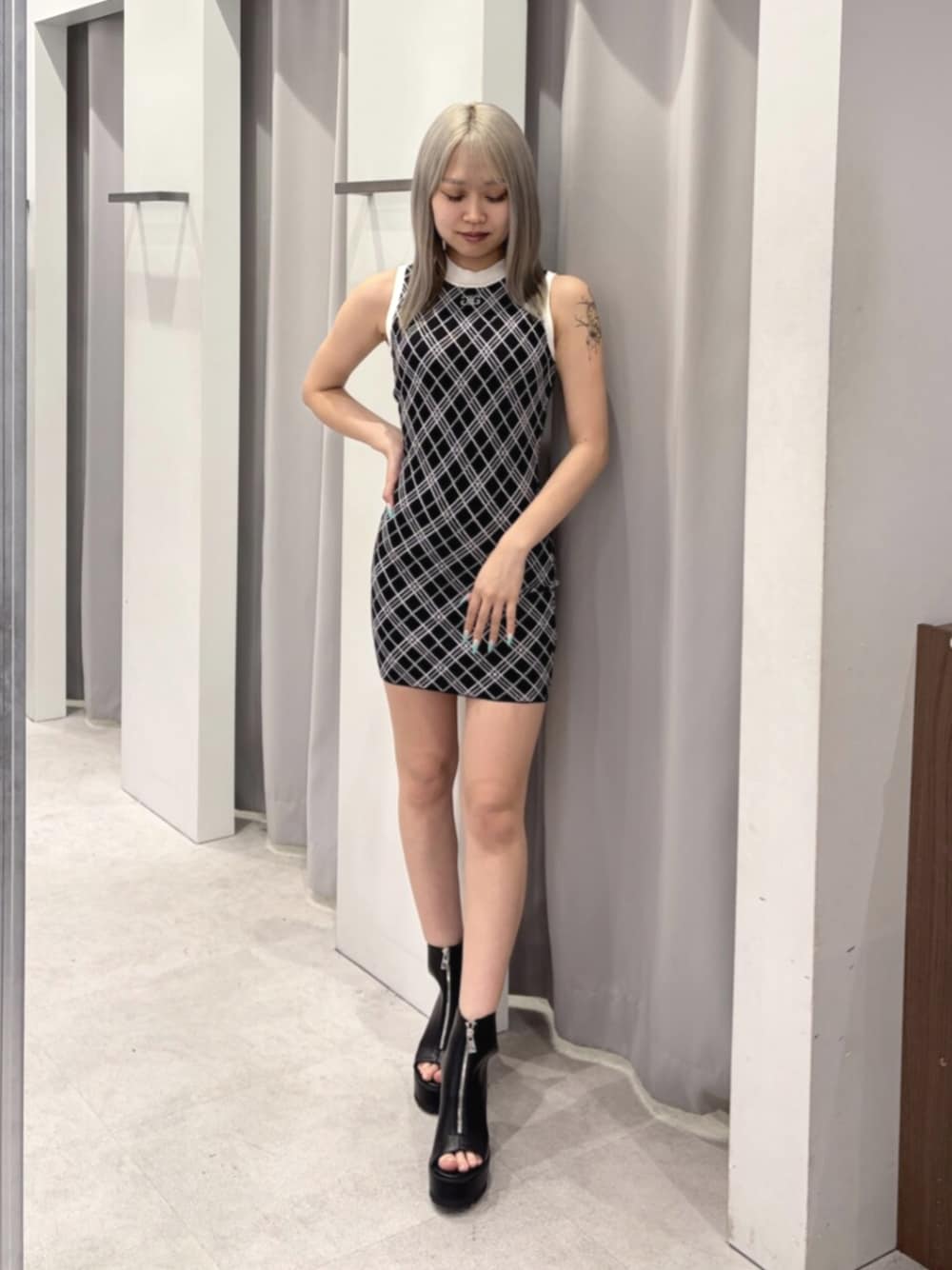ブラック系のワンピース、ブラック系のブーツを着用したレディースの夏コーディネートの1枚目の写真