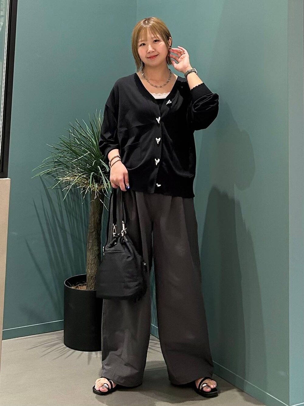 ブラック系のサンダル、グレー系のデニムパンツ、ブラック系のショルダーバッグを着用したレディースの夏コーディネートの1枚目の写真