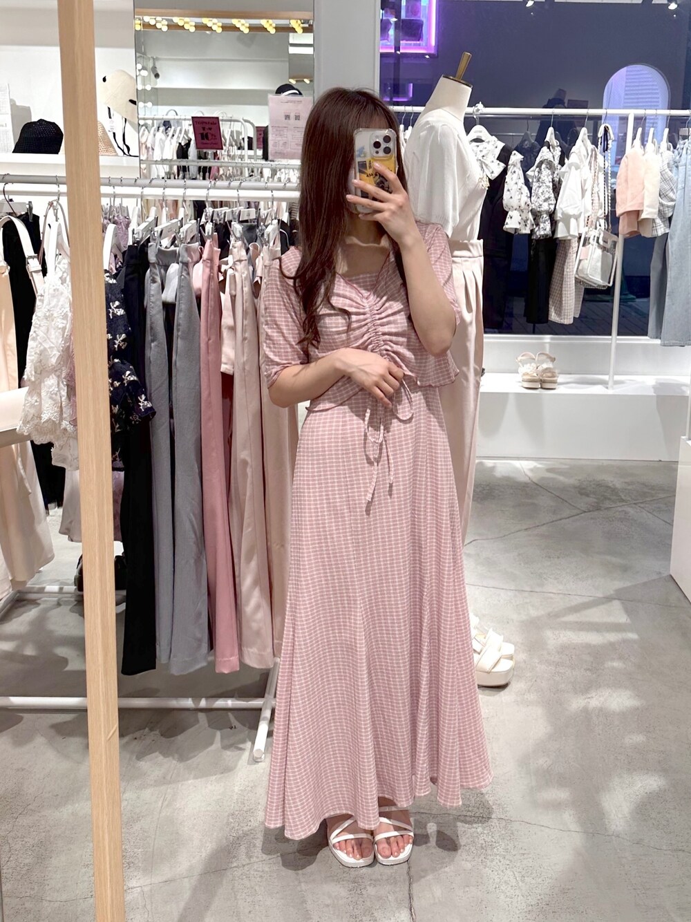 ピンク系のワンピース、ホワイト系のサンダルを着用したレディースの春コーディネートの1枚目の写真