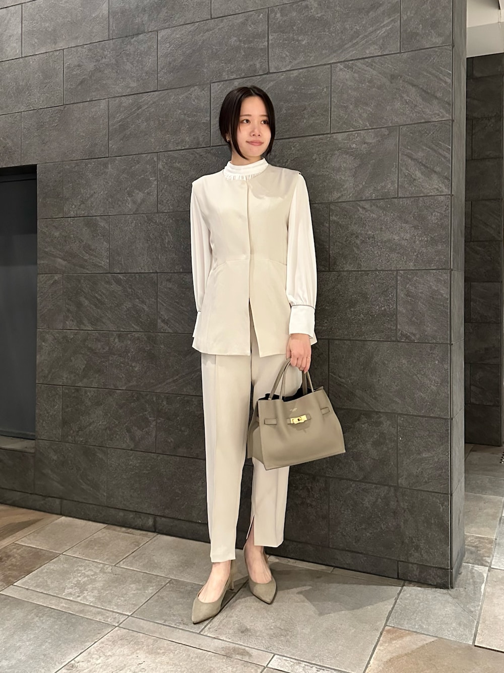 ホワイト系のセットアップ、ベージュ系のトートバッグ、ブラウン系のその他アウターを着用したレディースの冬コーディネートの1枚目の写真