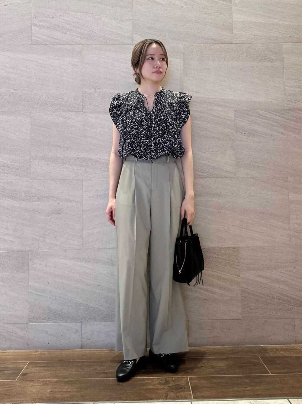 ブラウン系のその他パンツ、ブラック系のシャツ/ブラウス、ブラック系のショルダーバッグを着用したレディースの春コーディネートの1枚目の写真