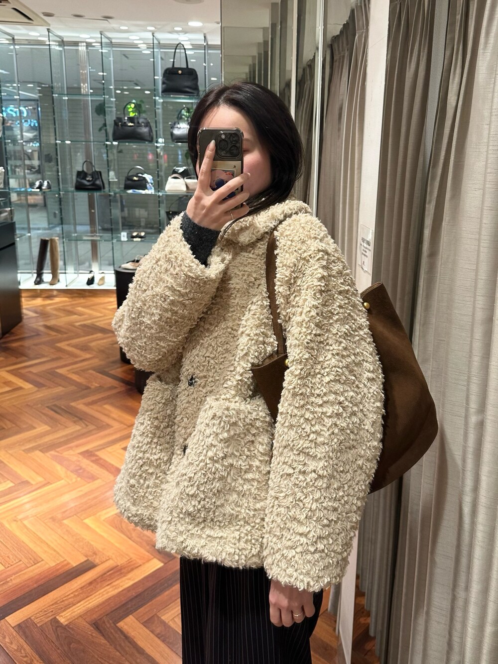 ホワイト系のその他アウター、ブラウン系のトートバッグ、その他のその他パンツを着用したレディースの冬コーディネートの1枚目の写真