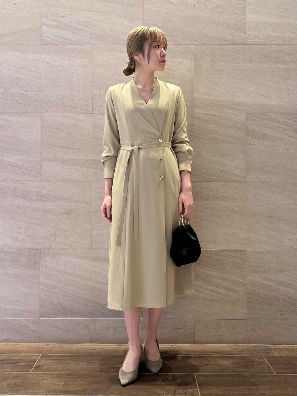 ブラウン系のパンプス、ブラック系のハンドバッグ、ベージュ系のワンピースを着用したレディースの冬コーディネートの1枚目の写真