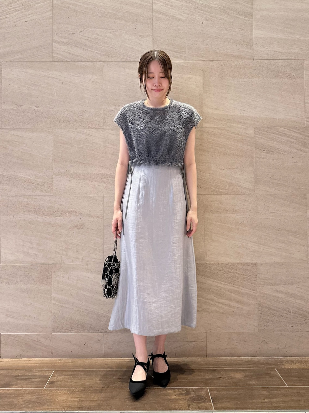 ブルー系のワンピース、ブラック系のハンドバッグ、ブラック系のパンプスを着用したレディースの夏コーディネートの1枚目の写真