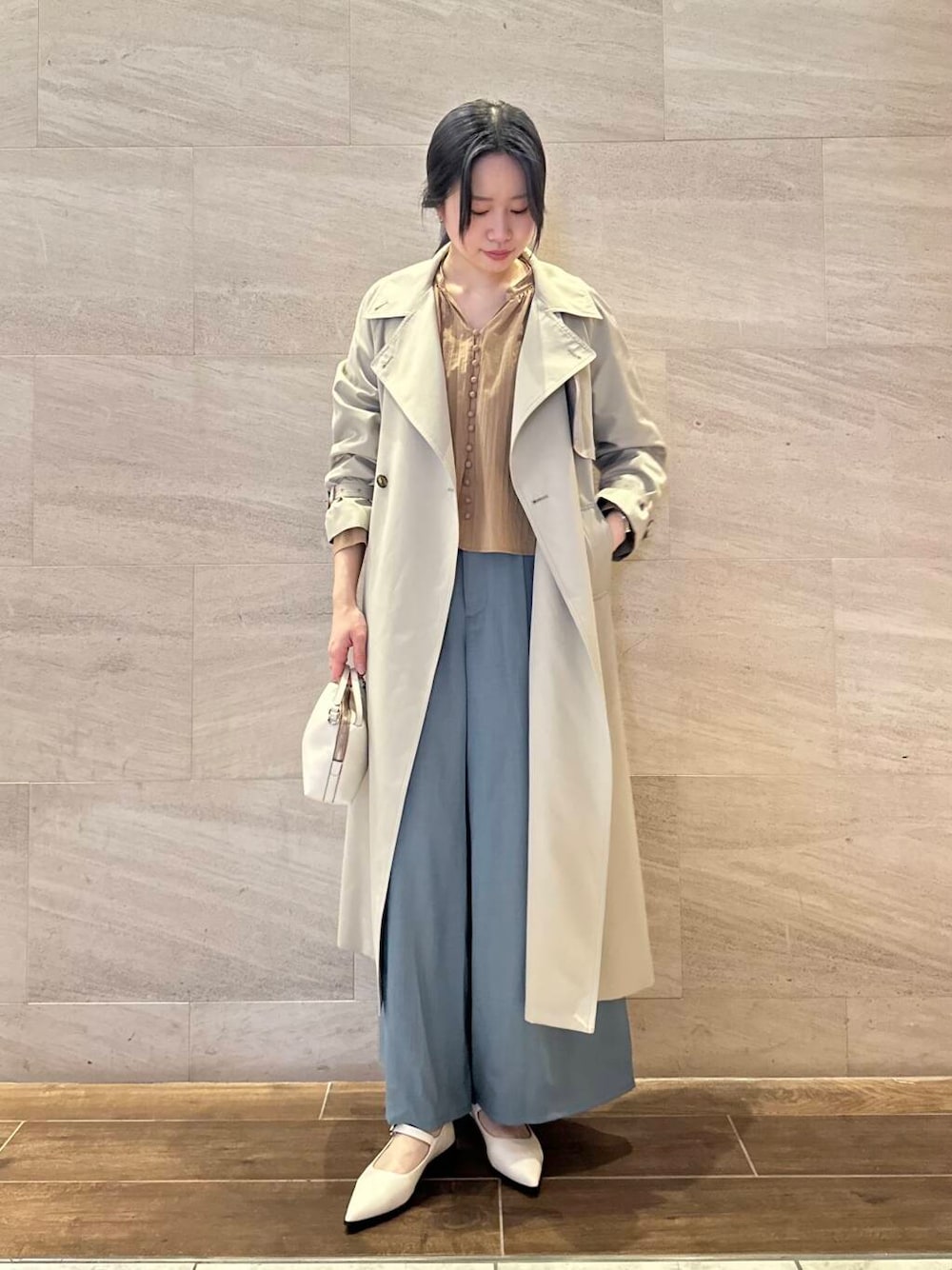 グレー系のトレンチコート、ブルー系のその他パンツ、イエロー系のシャツ/ブラウスを着用したレディースの春コーディネートの1枚目の写真