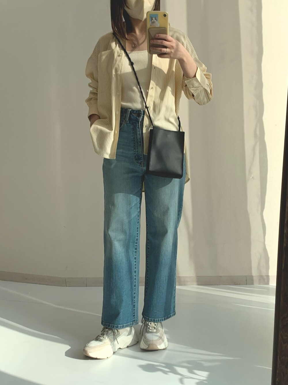 ブルー系のパンツ、ベージュ系のシャツ/ブラウスを着用したレディースの春コーディネートの1枚目の写真