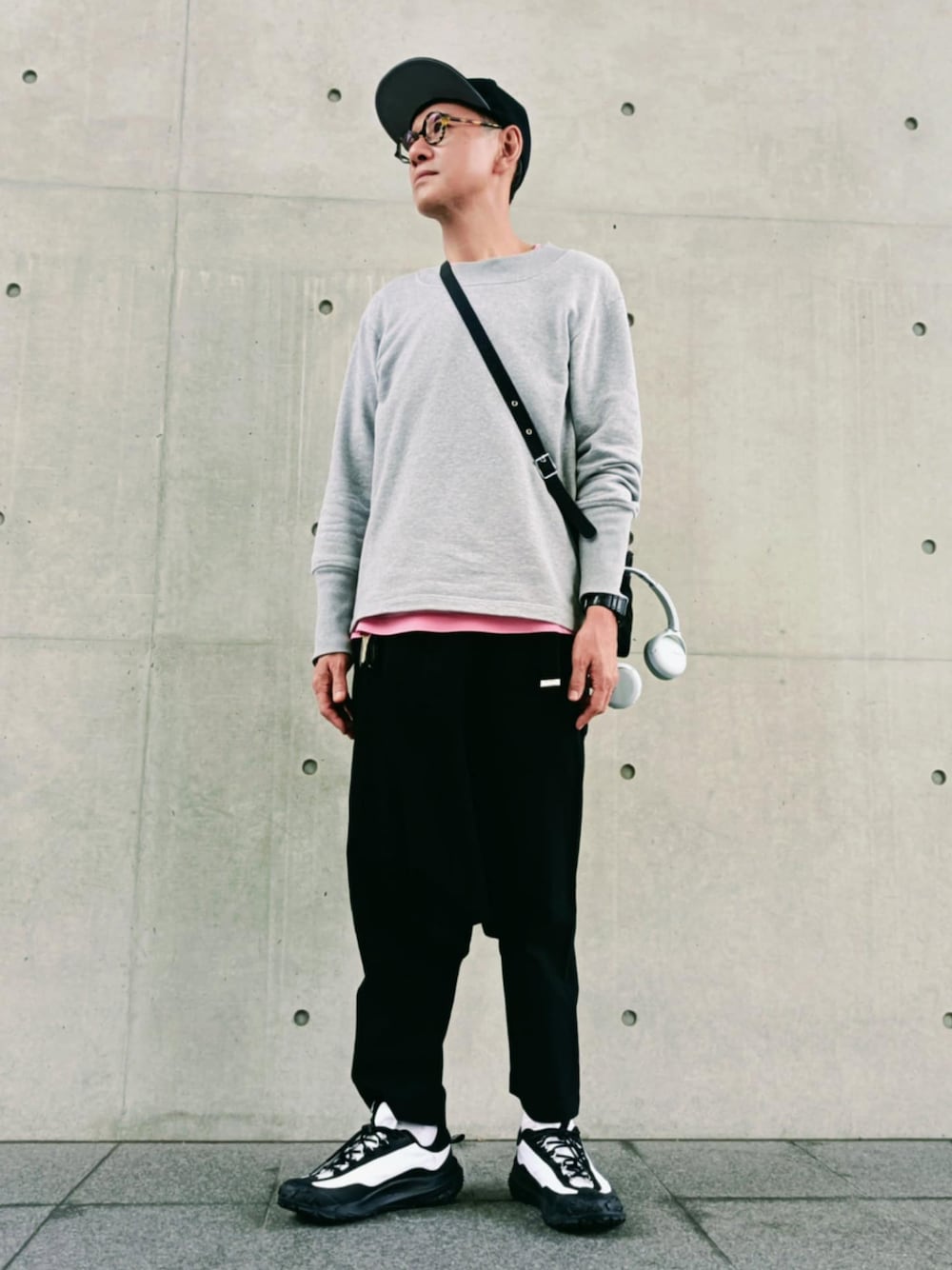 グレー系のTシャツ/カットソー、ホワイト系のスニーカー、ブラック系のキャップを着用したメンズの秋コーディネートの1枚目の写真