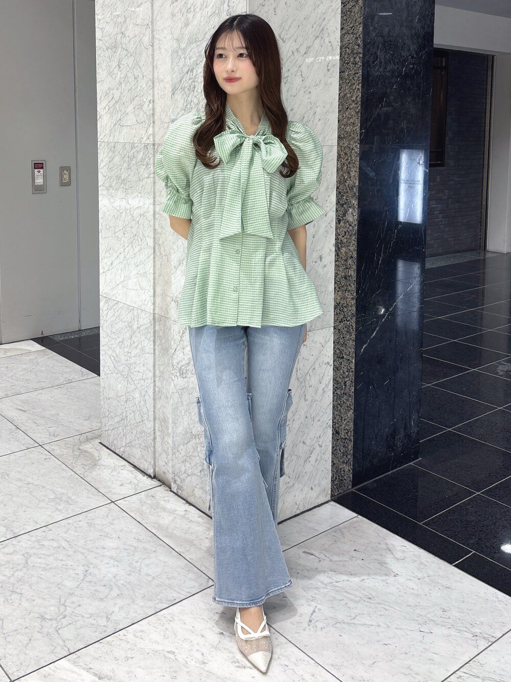 グリーン系のシャツ/ブラウス、ブルー系のデニムパンツ、ホワイト系のパンプスを着用したレディースの春コーディネートの1枚目の写真