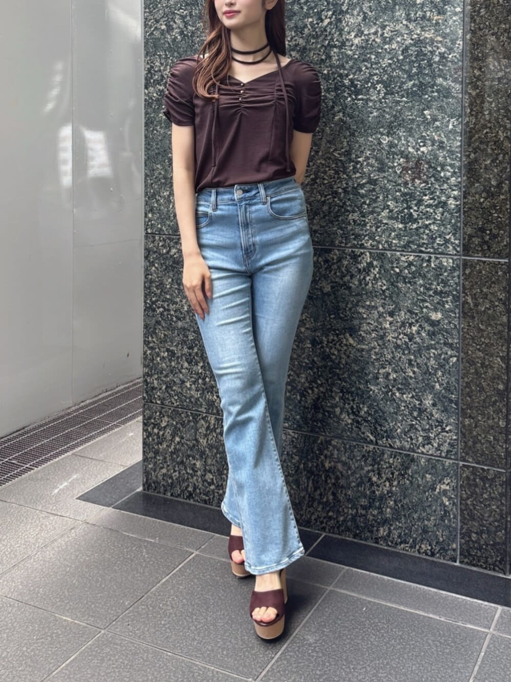 ブルー系のデニムパンツ、ブラウン系のTシャツ/カットソー、ブラウン系のサンダルを着用したレディースの春コーディネートの1枚目の写真
