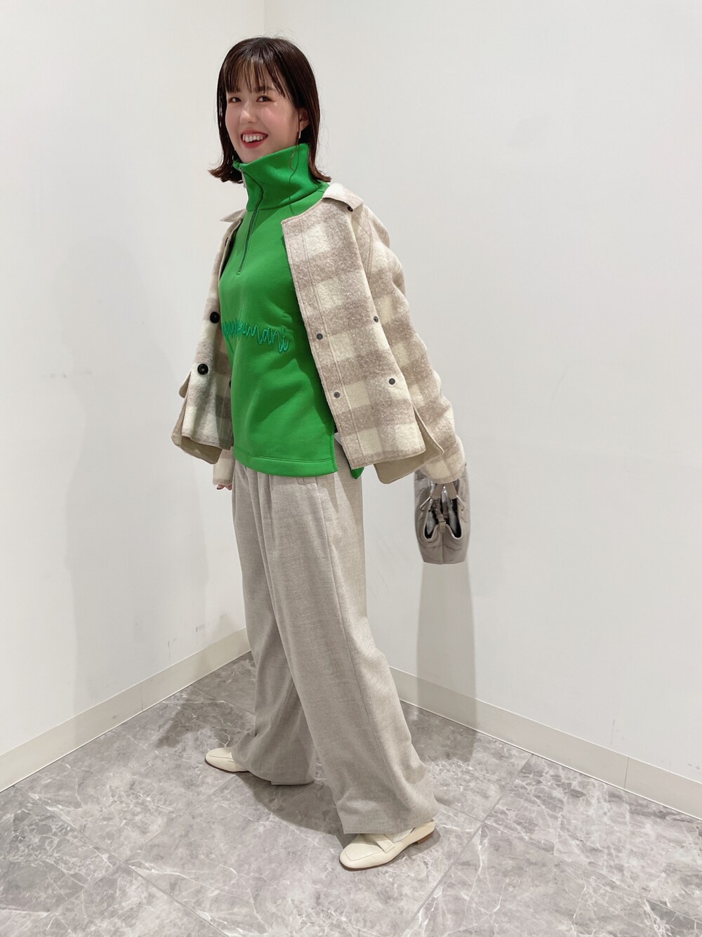 グリーン系のスウェット、ベージュ系のパンツ、ベージュ系のシューズを着用したレディースの秋コーディネートの1枚目の写真