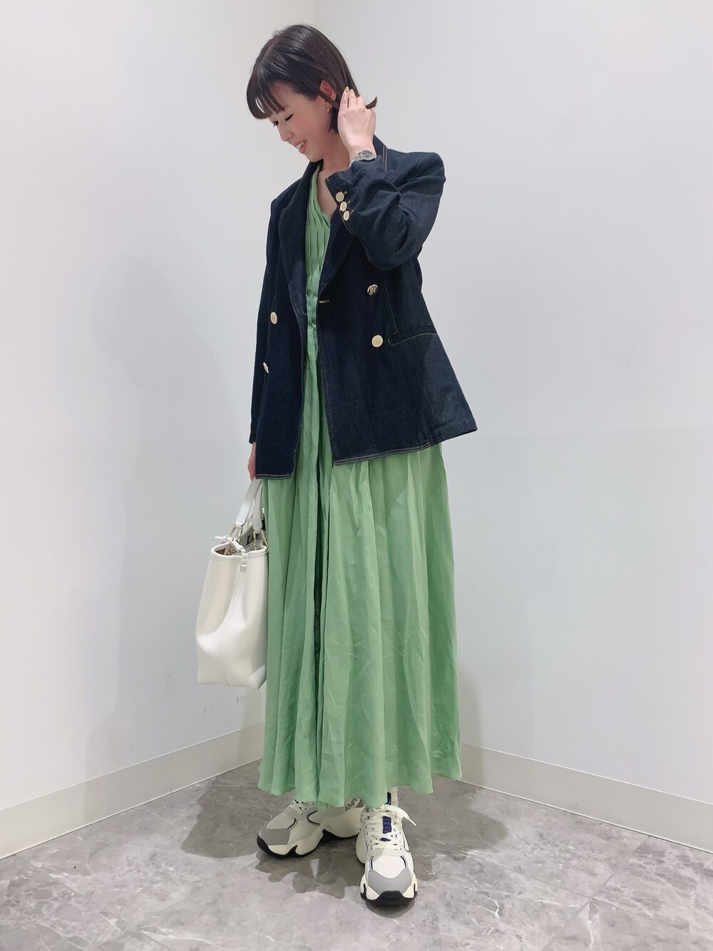 ブルー系のジャケット/アウター、グリーン系のワンピース、ホワイト系のハンドバッグを着用したレディースの夏コーディネートの1枚目の写真