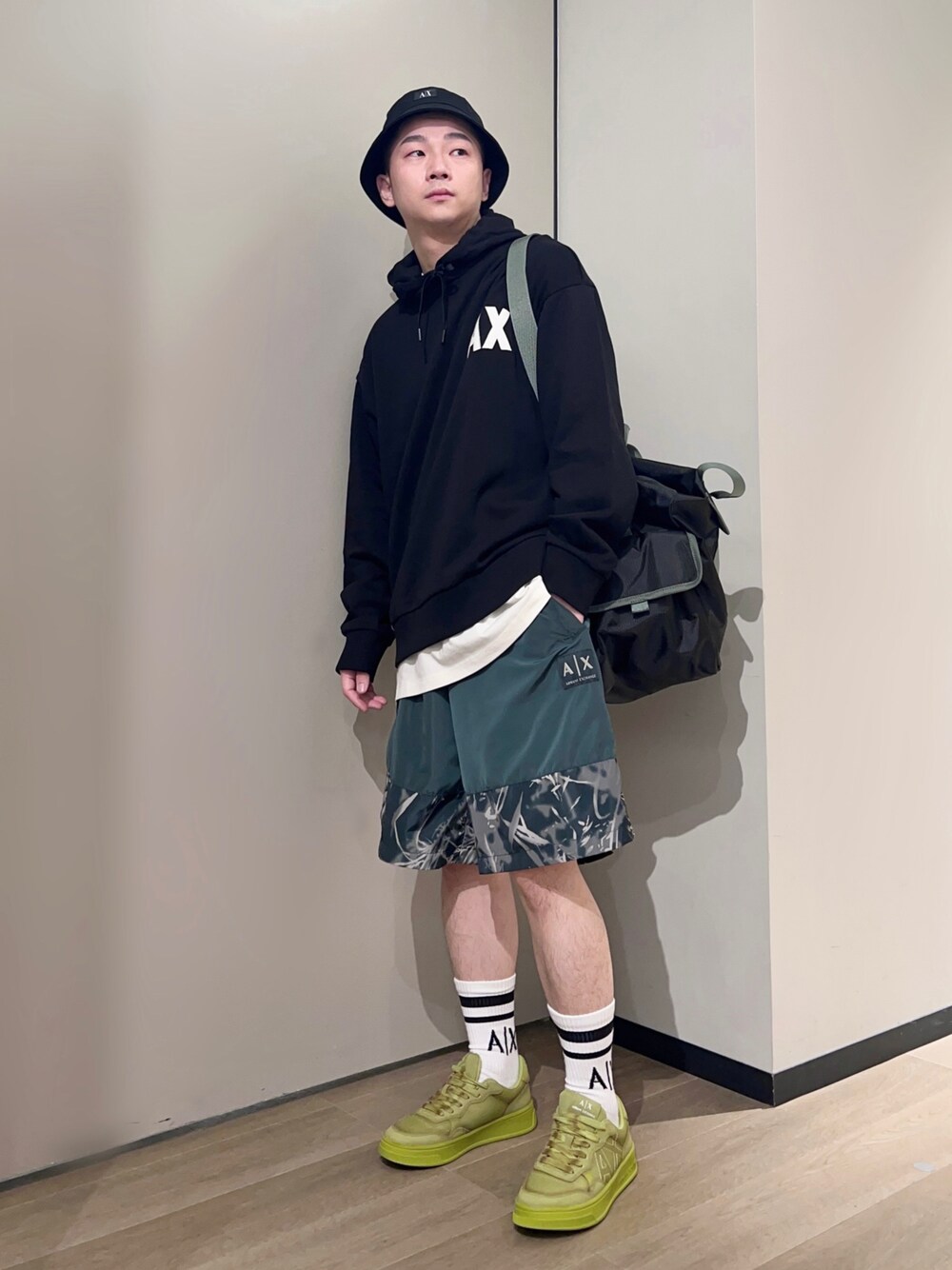 「AXchanger、AXchange、armaniexchange、アルマーニエクスチェンジ、バケットハット、ショップスタッフのアクティブコーデ、レイヤードスタイル、ロゴスウェット、ビッグシルエット、休日スタイル、スニーカー、ビタミンカラー、ストリート、ボストンバッグ、オーバーサイズ」｜「ARMANI EXCHANGEの【A|X アルマーニ エクスチェンジ】AXロゴ　レースアップスニーカー（スニーカー、イエロー系）」を使った、🔩J.HARAさん（メンズ・167cm）の春コーディネートの1枚目の写真