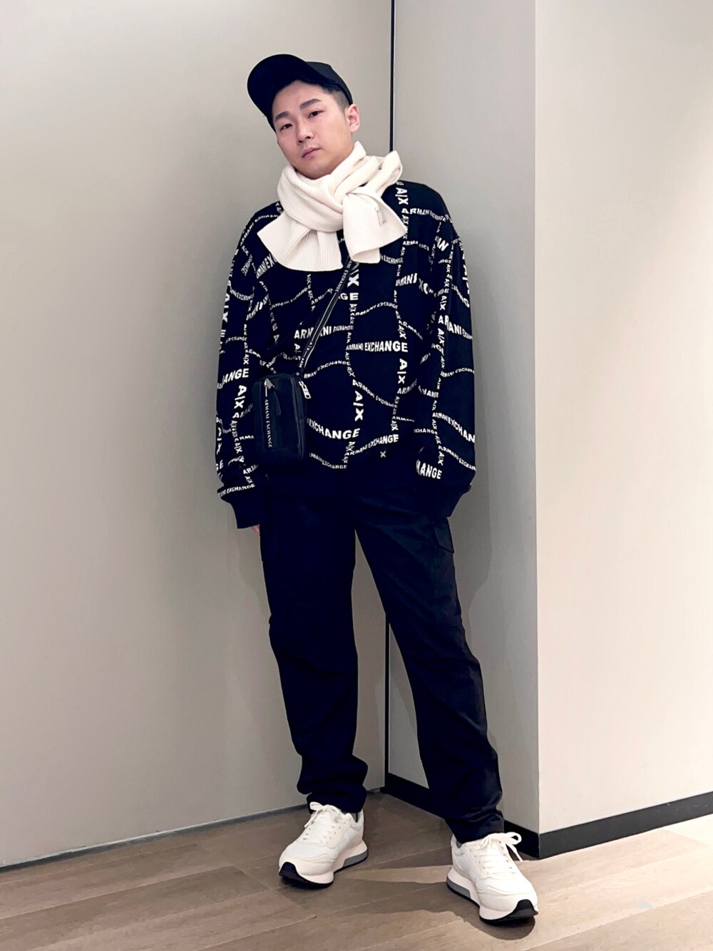 ホワイト系のスニーカー、ブラック系のチノパンツ、ホワイト系のマフラーを着用したメンズの冬コーディネートの1枚目の写真