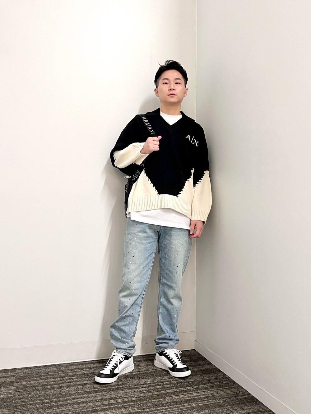 ブラック系のニット/セーター、ホワイト系のTシャツ/カットソー、ブラック系のショルダーバッグを着用したメンズの夏コーディネートの1枚目の写真