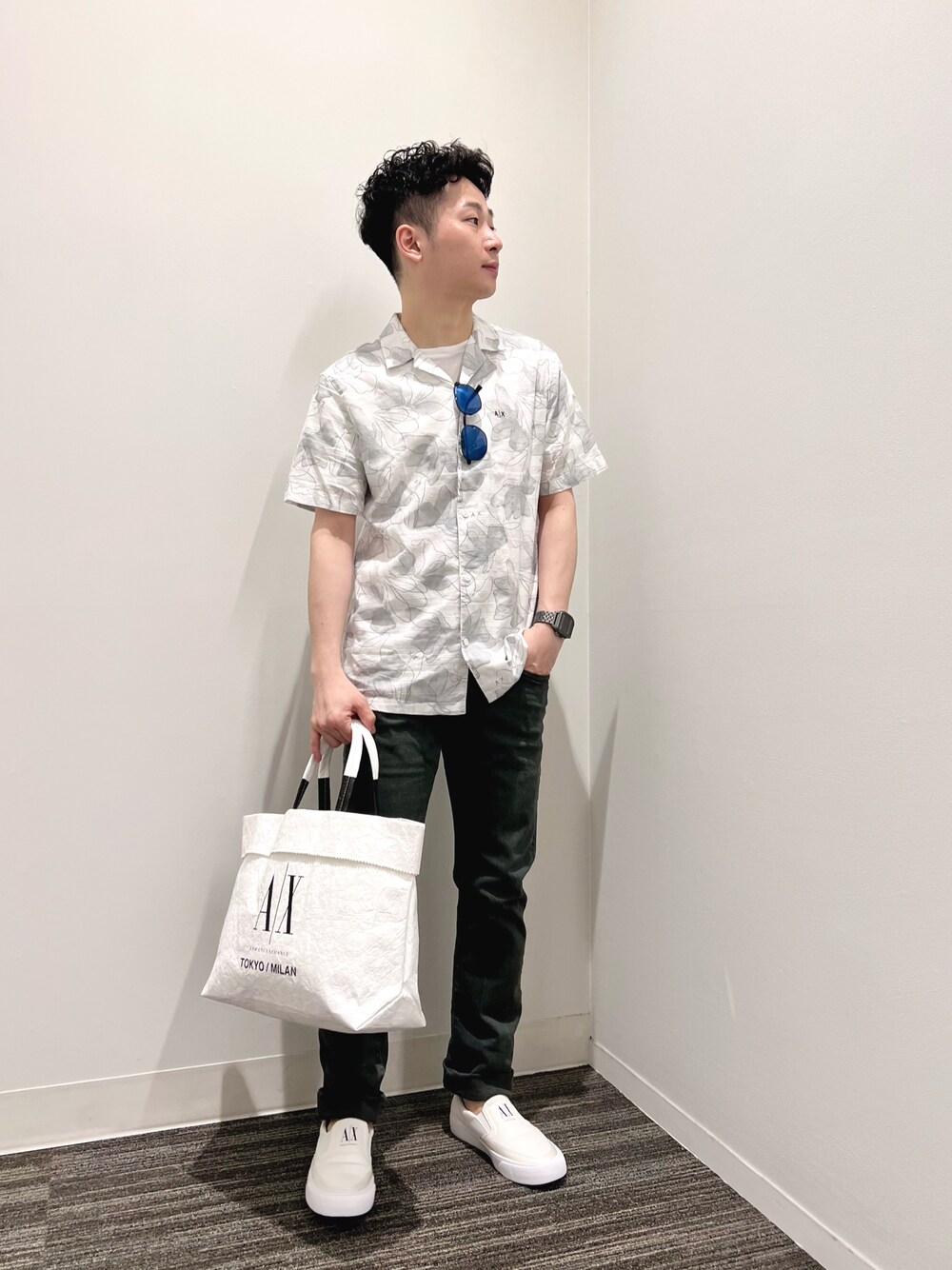 グリーン系のデニムパンツ、ホワイト系のトートバッグ、ホワイト系のスニーカーを着用したメンズの夏コーディネートの1枚目の写真