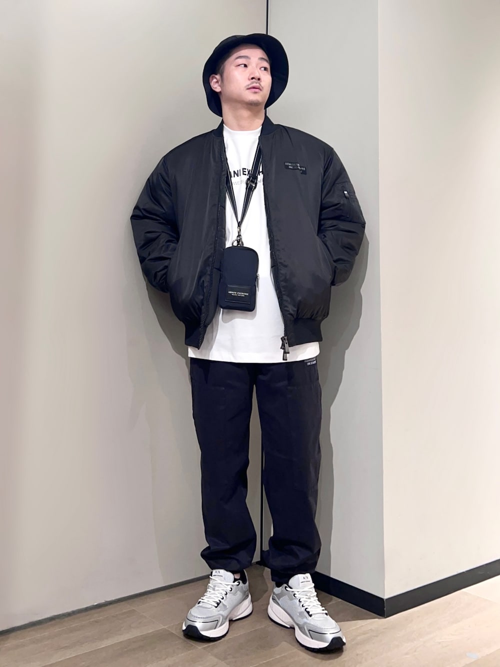 シルバー系のスニーカー、ブラック系のチノパンツ、ホワイト系のTシャツ/カットソーを着用したメンズの秋コーディネートの1枚目の写真