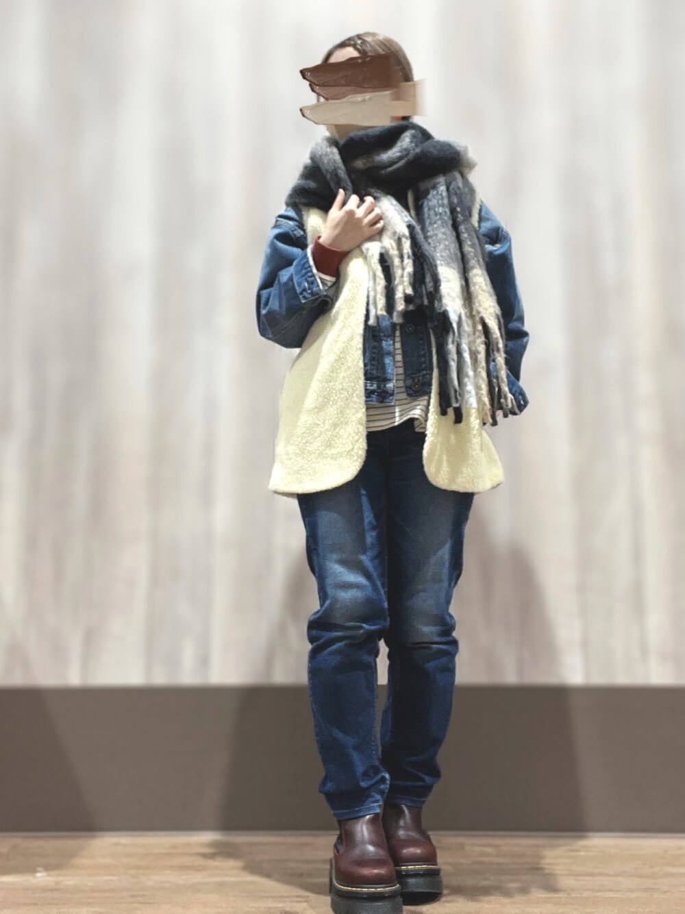 ブラウン系のブーツ、ブルー系のデニムパンツ、ホワイト系のベストを着用したレディースの冬コーディネートの1枚目の写真