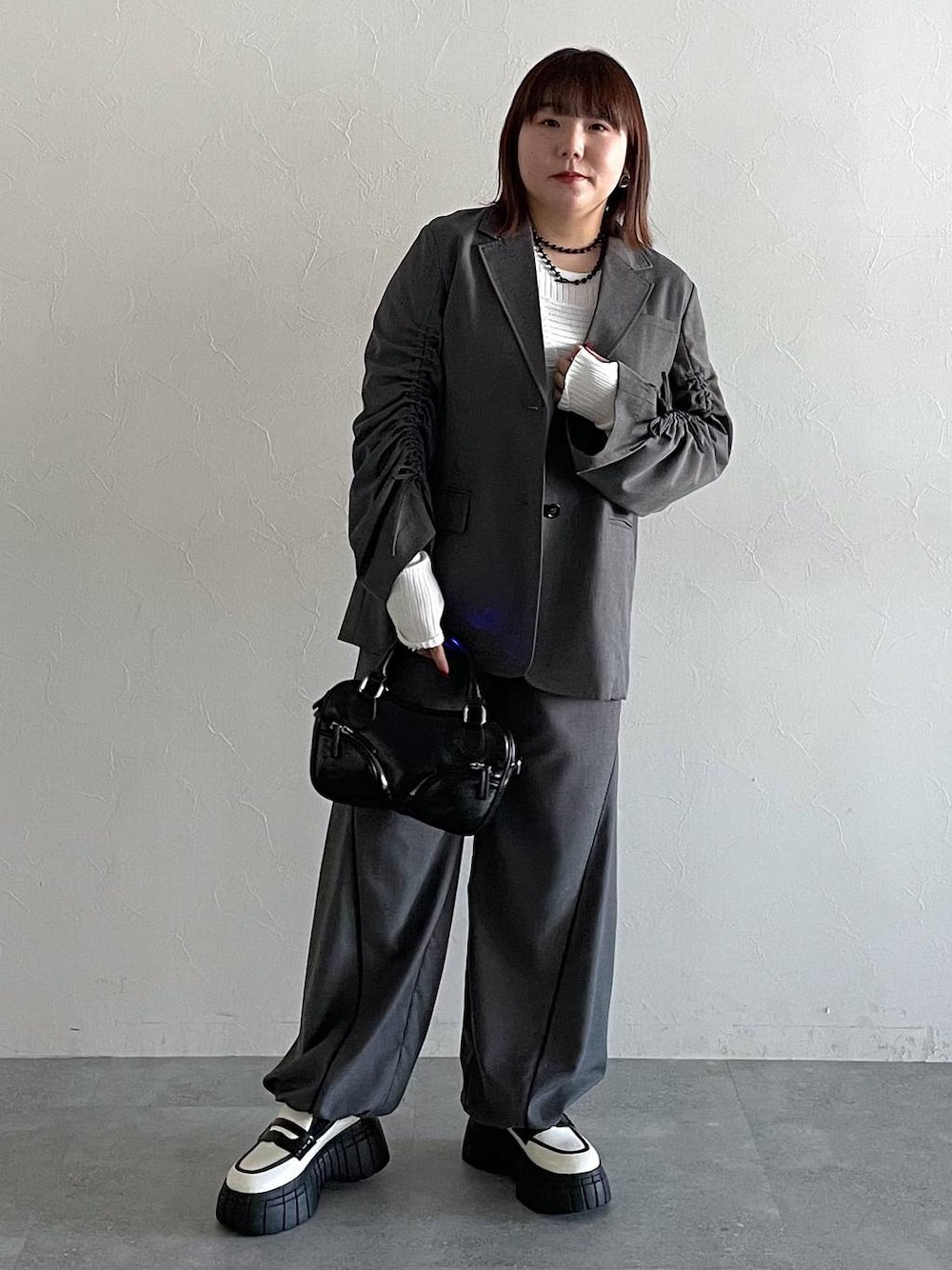 グレー系のその他パンツ、グレー系のテーラードジャケット、ホワイト系のローファーを着用したレディースの冬コーディネートの1枚目の写真